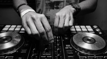 grayscale-photography-of-person-using-dj-controller-860707